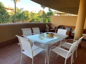 - une table et des chaises blanches sur la terrasse dans l'établissement Apartamento La Cala de Mijas, à La Cala de Mijas