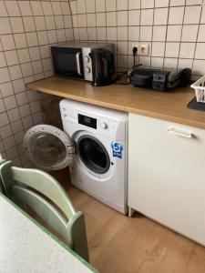 Un lave-linge est installé à côté d'un comptoir avec un four micro-ondes. dans l'établissement WG Zimmer 108, à Holzminden