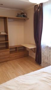 1 dormitorio con cama, escritorio y ventana en Кандавас 9, en Daugavpils