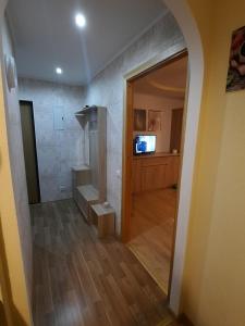 a bathroom with a shower in a room with a wooden floor at Кандавас 9 in Daugavpils