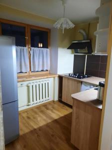eine Küche mit Arbeitsflächen aus Holz und einem weißen Kühlschrank in der Unterkunft Кандавас 9 in Daugavpils