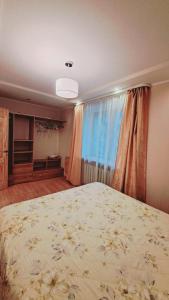 ein Schlafzimmer mit einem großen Bett und einem Fenster in der Unterkunft Кандавас 9 in Daugavpils