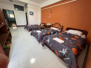 two beds in a hotel room with a room with two at GG Sweet Home in Mae Sot