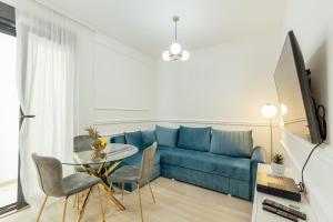 sala de estar con sofá azul y mesa de cristal en Miracle apartment, en Kotor