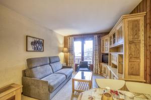 ein Wohnzimmer mit einem Sofa und einem Tisch in der Unterkunft Studio cabine Le Charvet in Le Grand-Bornand