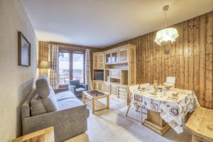 salon z kanapą i stołem w obiekcie Studio cabine Le Charvet w mieście Le Grand-Bornand