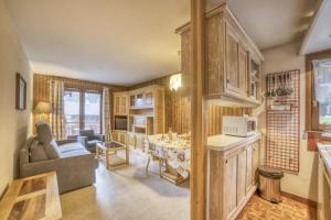 kuchnia i salon z kanapą i stołem w obiekcie Studio cabine Le Charvet w mieście Le Grand-Bornand