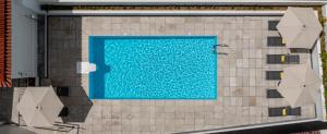 an overhead view of a swimming pool with two umbrellas at Olive Boutique Guesthouse in Vila Franca do Campo