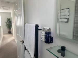 a bathroom with a mirror and towels on a wall at Denburn Cottage, East Neuk of Fife in Colinsburgh