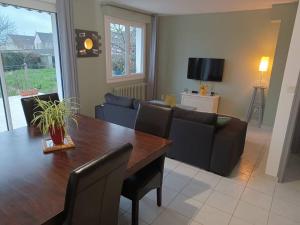 a living room with a table and a couch at Maison chaleureuse, gîte pour famille, amis, ouvriers... in Château-Gontier