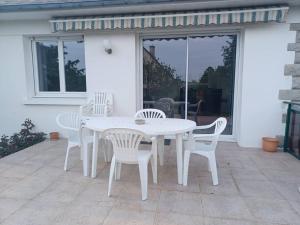 a white table and chairs on a patio at Maison chaleureuse, gîte pour famille, amis, ouvriers... in Château-Gontier