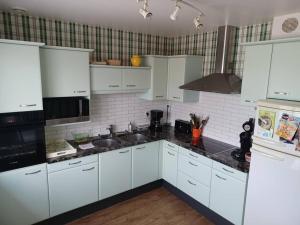 a kitchen with white cabinets and black counter tops at Maison chaleureuse, gîte pour famille, amis, ouvriers... in Château-Gontier