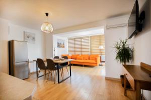 a living room with a table and an orange couch at Cozy Apartment with Mountain View & Parking in Sofia