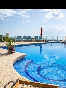 a large blue swimming pool with chairs and the ocean at Ons Spanje in Calpe +14 photos