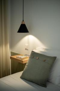 a bed with a pillow and a table with a lamp at Olive Boutique Guesthouse in Vila Franca do Campo