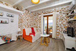 a living room with a stone wall at Olivia's Countryside House in Krotiri