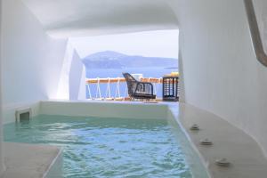 a pool in a house with a view of the water at Luxus VIP Suites in Oia