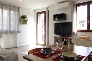 een woonkamer met een tafel met wijnglazen bij Cisano Holiday Apartment in Bardolino