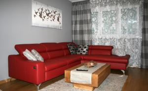 Sala de estar con sofá rojo y mesa de centro en Exklusive Familienapartment Alpin, en Garmisch-Partenkirchen