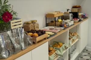 a shelf filled with lots of different types of food at Olive Boutique Guesthouse in Vila Franca do Campo
