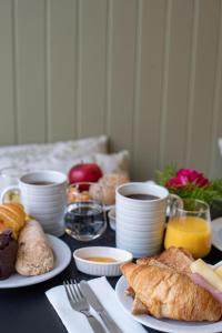 a table topped with plates of pastries and cups of coffee at Olive Boutique Guesthouse in Vila Franca do Campo