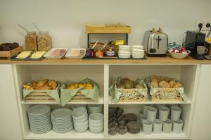 a shelf filled with plates and other food at Olive Boutique Guesthouse in Vila Franca do Campo