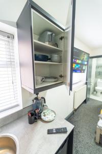 a kitchen with a counter with a sink and a cupboard at Lovely Studio in Selly Oak 10 mins from city! in Birmingham