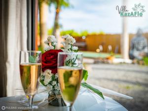 duas taças de champanhe numa mesa com flores em La villa KazAFlo Piscine, jacuzzi, SPA, brasero em Saint-Joseph