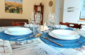 uma mesa com pratos e copos por cima em Myrea House em Avola
