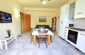 uma cozinha e sala de jantar com mesa e cadeiras em Myrea House em Avola