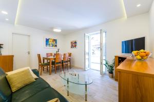 a living room with a green couch and a table at Apartment Luxe in Dubrovnik