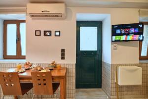 a kitchen with a table and a green door at #Tyrtaiou Modern Design Studio in Mytilene