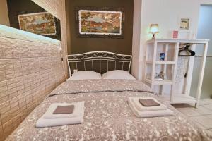 a bedroom with a bed with two towels on it at #Tyrtaiou Modern Design Studio in Mytilini