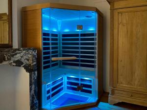 um armário de vidro com luzes azuis dentro dele em Les Valcaprimontoises … en ville ! em Liège
