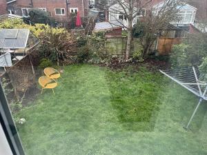 a yard with a yellow chair in the grass at Stunning 3-bedroom Great Sankey Home in Great Sankey