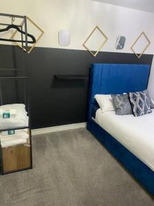 pokój z łóżkiem z niebieską głową w obiekcie Stunning 3-bedroom Great Sankey Home w mieście Great Sankey