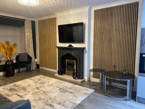 a living room with a fireplace with a tv above it at Stunning 3-bedroom Great Sankey Home in Great Sankey