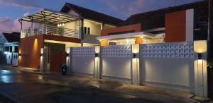 a white fence in front of a house at Alexandria12 Guest House in Selong