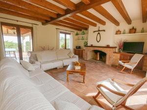 un soggiorno con divano e camino di Sa Sinia - Family rural house with pool and mountain views a S'Horta