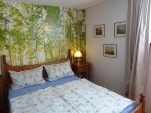 ユーバーゼーにあるHaus-Monika-am-Chiemseeのベッドルーム1室(壁に絵画が描かれたベッド1台付)