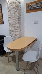 a wooden table and two white chairs in a room at ayacucho pb B un dormitorio in Resistencia