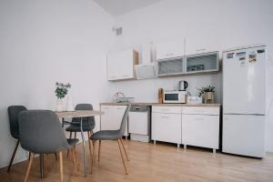 a kitchen with white appliances and a table and chairs at Piotrkowska Green quiet spot in Łódź