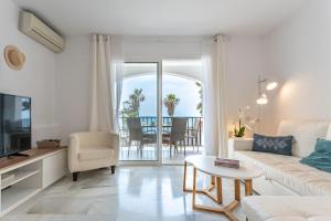 salon z kanapą, telewizorem i stołem w obiekcie Dona Lola Micaela Beach front duplex apartment with open sea and beach views located between Marbella and Fuengirola - Costa del Sol - CS148 w mieście Mijas