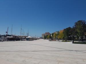 a large open plaza with trees and a blue sky at Poreč old town, apartments in Poreč