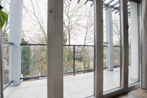 uma janela aberta com vista para uma varanda em Family Apartments by Hi5 - Zamardi em Zamárdi