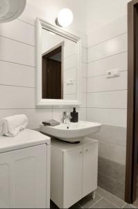 a white bathroom with a sink and a mirror at Family Apartments by Hi5 - Zamardi in Zamárdi