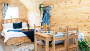 a bedroom in a log cabin with a bed and a table at Dwell on the Moor in Holme upon Spalding Moor