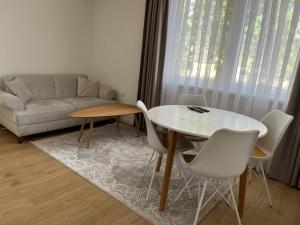 a living room with a table and chairs and a couch at Mia apartman Visoko in Visoko