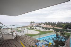 uma varanda com vista para uma piscina e para o oceano em Thalassa Luxury Apartment em Protaras