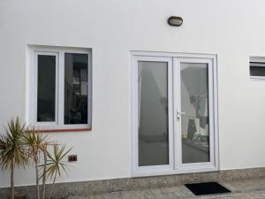 dos ventanas en el lateral de una casa blanca en Habitación privada con baño, en Lima